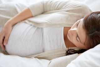 Une femme enceinte allongée sur un lit